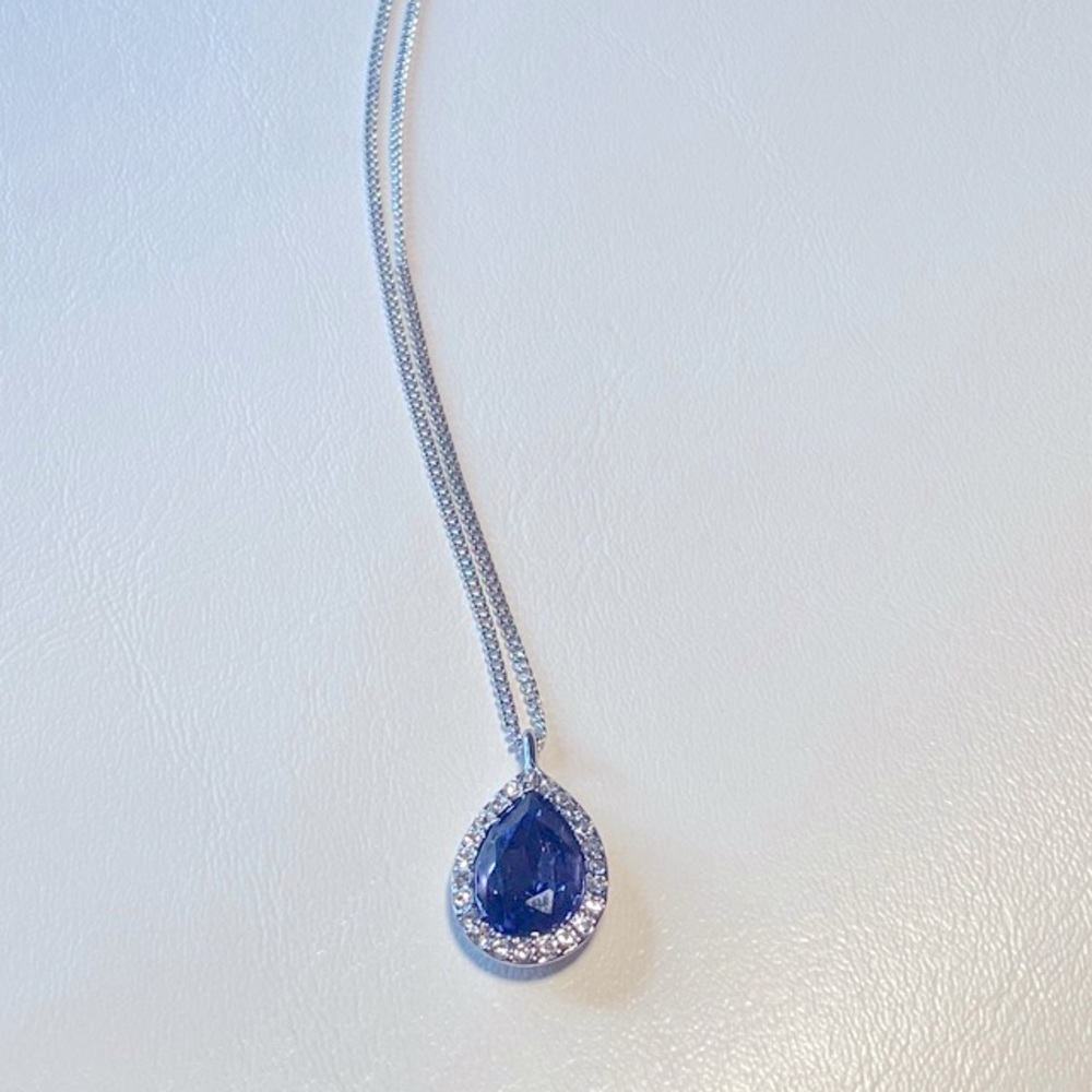 Givenchy with deep purple pendant necklace.